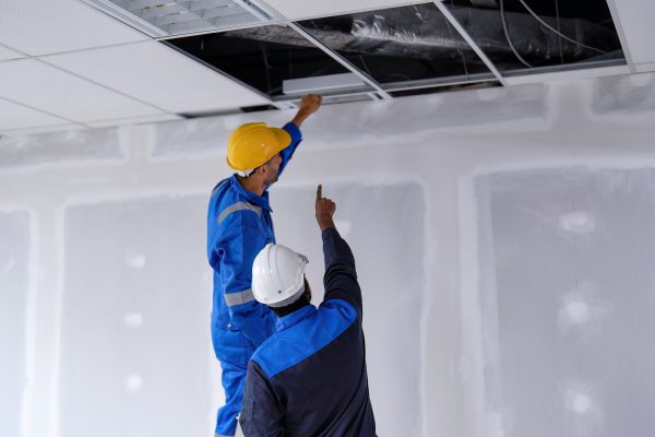 At new construction building worker open ceiling to check air condition duct on the top